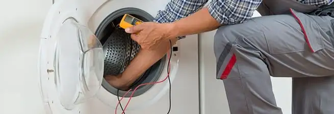 Dryer repair technician inspecting and repairing a clothes dryer in Saint Petersburg, FL