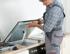 Appliance repair technician installing a built-in cooktop in Saint Petersburg, FL