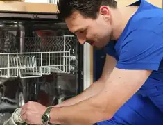 Dishwasher repair technician inspecting and servicing an open dishwasher in Saint Petersburg, FL