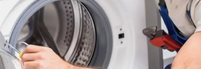 Appliance technician repairing a clothes dryer drum and internal parts in Saint Petersburg, FL