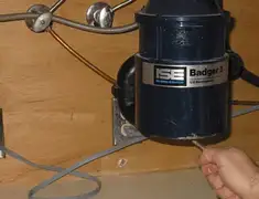 Garbage disposal repair technician tightening the mounting ring under a sink in Saint Petersburg, FL