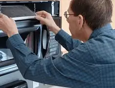 Appliance repair technician replacing a microwave vent filter in Saint Petersburg, FL