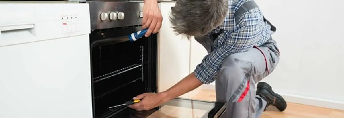 Oven repair technician inspecting and servicing an electric oven in Saint Petersburg, FL