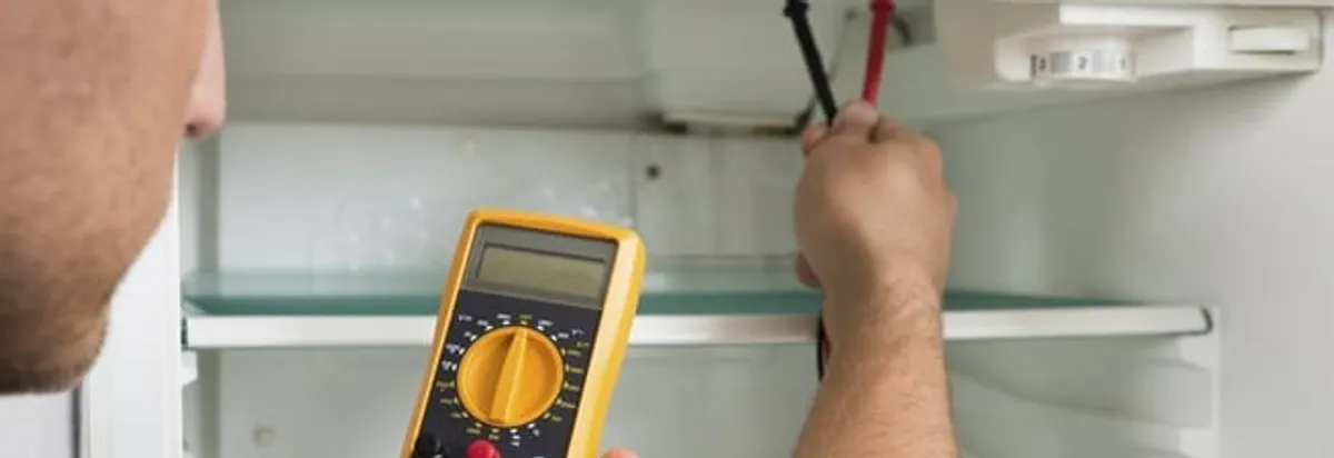 Refrigerator repair technician testing electrical components with a multimeter in Saint Petersburg, FL