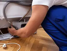 Appliance repair technician fixing refrigerator water line and connections in Saint Petersburg, FL