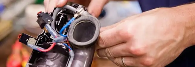 Vacuum repair technician reconnecting wiring and components in Saint Petersburg, FL