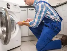 Washing machine repair technician servicing a front-load washer in Saint Petersburg, FL