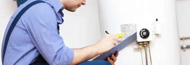 Water heater repair technician inspecting the unit and recording service notes in Saint Petersburg, FL