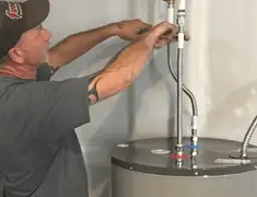 Water heater repair technician tightening supply line connections in Saint Petersburg, FL