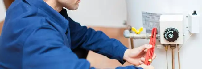 Water heater repair technician adjusting the temperature control and gas valve in Saint Petersburg, FL